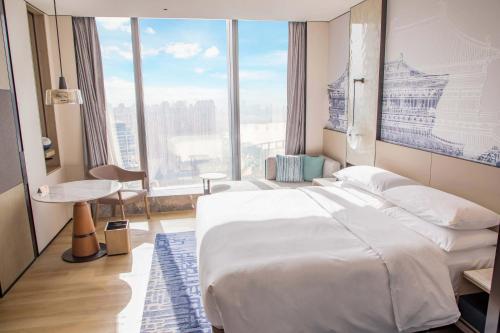 武汉武汉襄投万豪酒店的一间卧室设有一张大床和一个大窗户