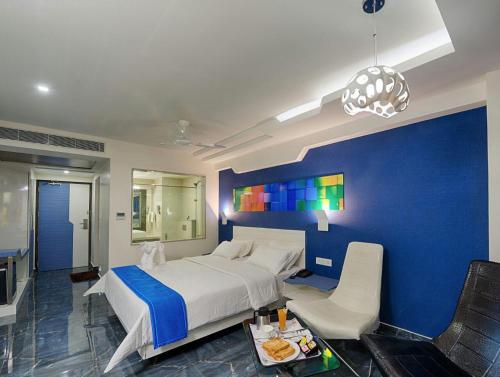 哥印拜陀Hotel Vijay Elanza的一间卧室设有一张大床和蓝色的墙壁