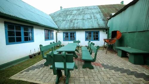 努沃勒埃利耶Country cottage的一组绿色野餐桌,位于大楼前