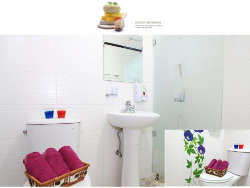 统营市Paper island pension的浴室配有水槽和带紫色毛巾的卫生间。