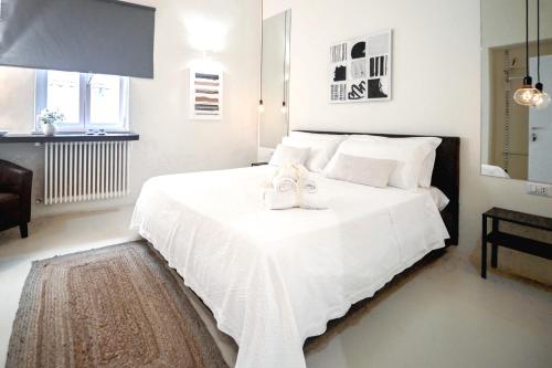 特拉尼42 Zanardelli B&B的卧室配有白色的床和两双鞋