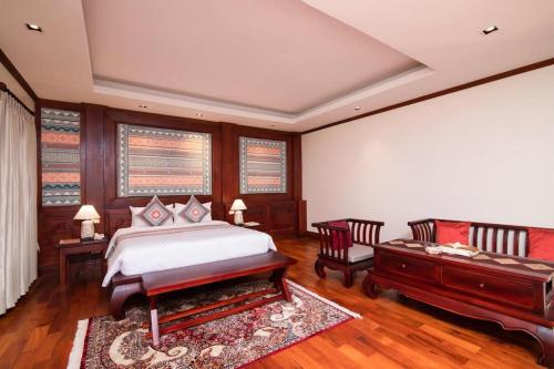 琅勃拉邦Houngvilai Hotel的卧室配有一张床和一张桌子及椅子