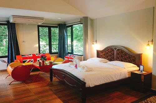 佛统Busaya Resort & Cuisine的卧室配有一张床和一张桌子及椅子
