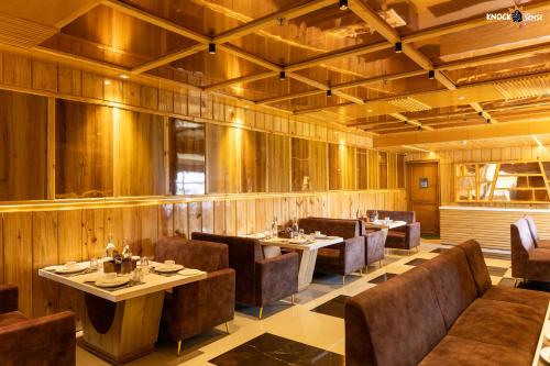 勒克瑙The Ecstasy Hotel的餐厅拥有木墙和桌椅