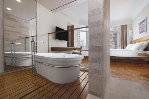 香港铜锣湾如心酒店的带浴缸、水槽和床的浴室