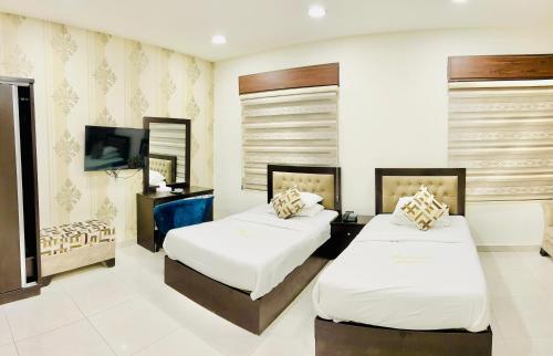 安曼Panorama Amman Hotel的酒店客房设有两张床和电视。