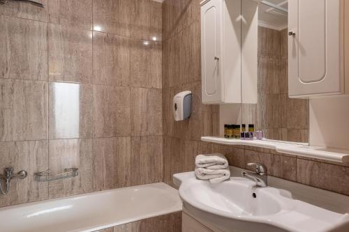 普拉塔尼亚斯Caldera Bay的一间带水槽、浴缸和镜子的浴室