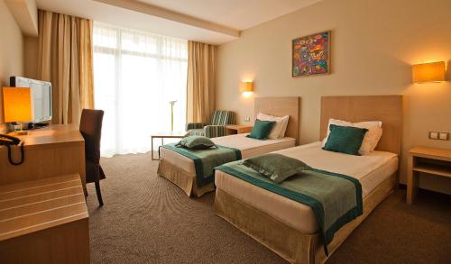 圣君士坦丁和海伦那Azalia Beach Hotel Balneo & SPA的酒店客房配有两张床和一张书桌