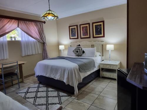 克鲁格斯多普非洲天空旅馆的一间卧室设有一张大床和一个窗户。