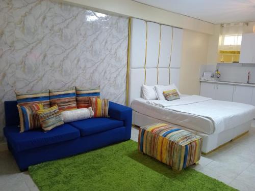 内罗毕Airport Studio Apartments-JKIA的一间卧室配有一张床和一张蓝色的沙发