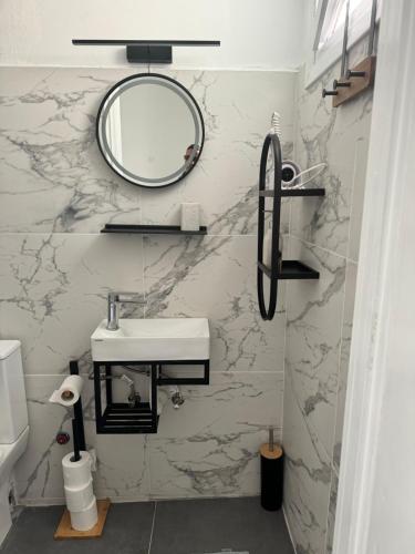 埃尔莫波利斯BYZANTIUM APARTMENTS的浴室设有水槽和墙上的镜子