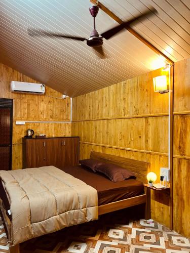 波戈马洛Stay In Woods的卧室配有木墙内的一张床