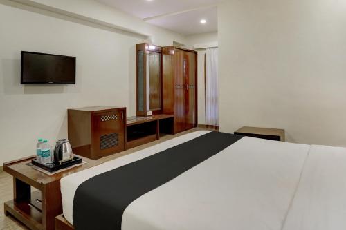 班加罗尔Super Townhouse Koramangala的一间卧室配有一张大床和电视