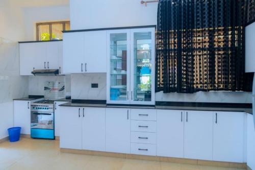 鲁亨盖里Douglas Home的厨房配有白色橱柜和玻璃冰箱