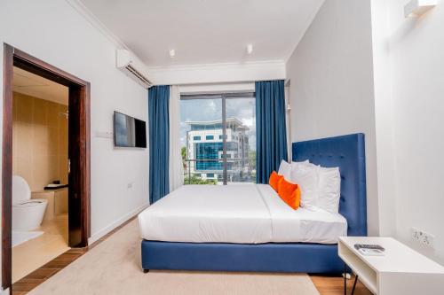 达累斯萨拉姆Urban by CityBlue, Dar es Salaam的卧室配有蓝色和白色的床和窗户。
