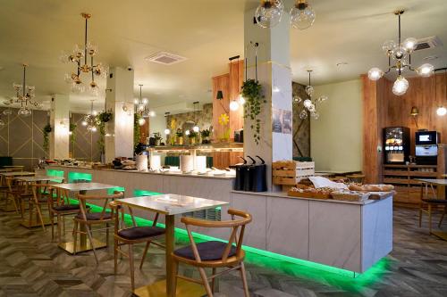 斯维诺乌伊希切ApartPark Baltic Home的餐厅设有桌子和带绿灯的柜台。