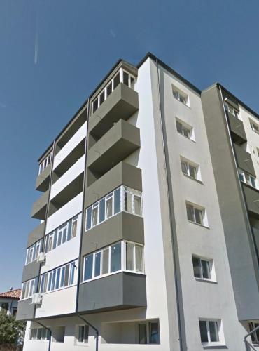 布加勒斯特Relax Regim Apartament的公寓大楼面对蓝色的天空