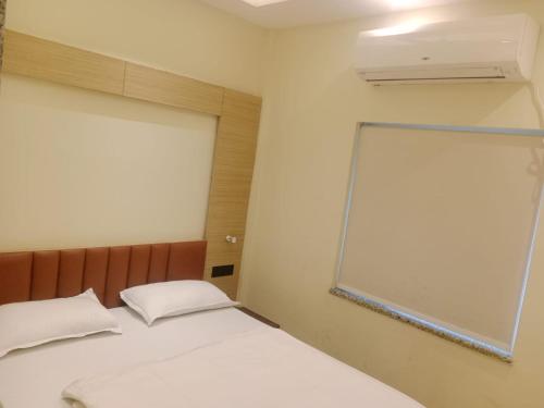 GauripurHOTEL SKYKING的卧室配有白色的床和窗户。