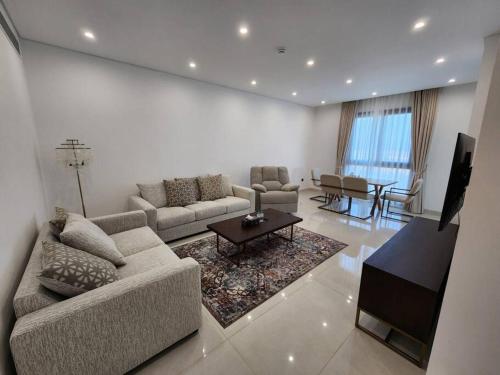 锡卜Beachfront 2BHK apartment at Al Mouj的客厅配有沙发和桌子