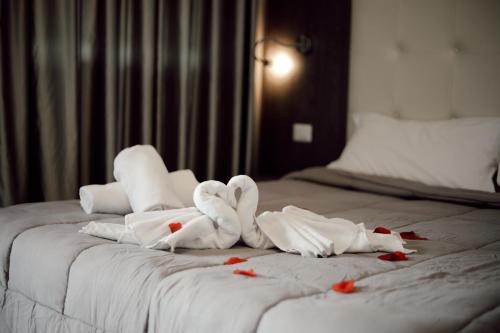 塔兰托蓝湾度假公寓的一张带毛巾的床,上面有如心形的毛巾