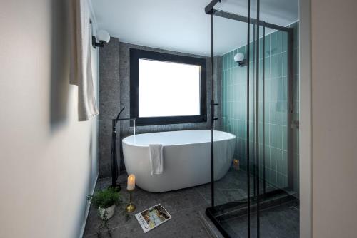 雅典Bonnie Athens by Nin&Bau的带浴缸和玻璃淋浴间的浴室。