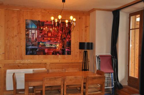莱德萨阿尔卑斯Cortina - 12 - Appart confort - 8 pers的一间带桌子和吊灯的用餐室
