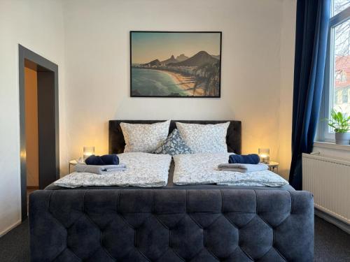 哥廷根Apartment Goethe in der Göttinger Innenstadt的一间卧室配有一张带蓝色软垫床头板的床
