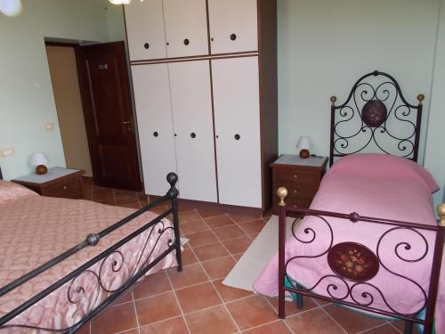 科皮托B&B Il Giardino Acquatico的一间卧室配有一张带粉色床单和白色橱柜的床。