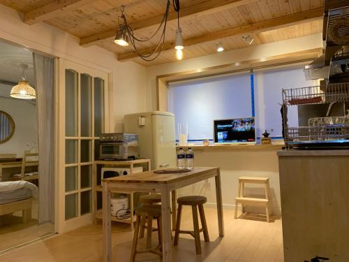 首尔liilliil Residence Seoul的厨房配有桌椅和冰箱。