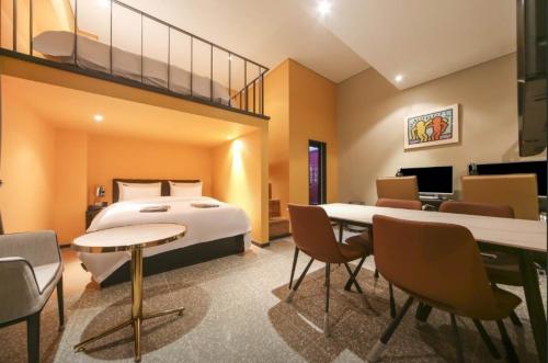 仁川市Incheon Browndot Hotel Nonhyeon Soraepogu的酒店客房带一张床、一张桌子和椅子