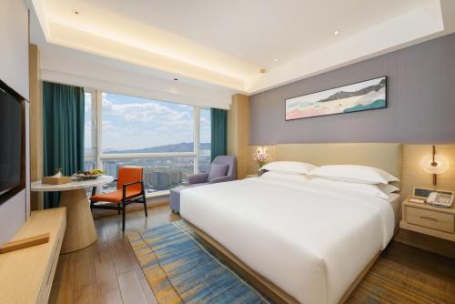 乌鲁木齐乌鲁木齐罗岚酒店的酒店客房设有一张白色大床和一张书桌