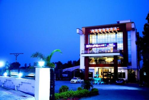 AyodhyaTaraji Resort Hotel & Restaurant Ayodhya的夜间停车的建筑物