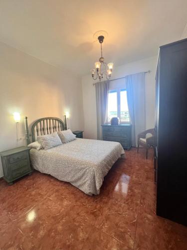 洛斯·亚诺斯·德·阿里丹Aceró Home的一间卧室配有一张床和一个吊灯