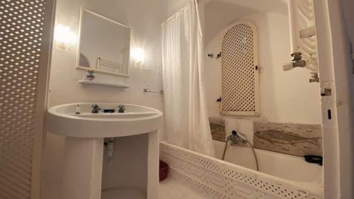 哈马马特Dar Essarouel Hammamet的白色的浴室设有水槽和浴缸。