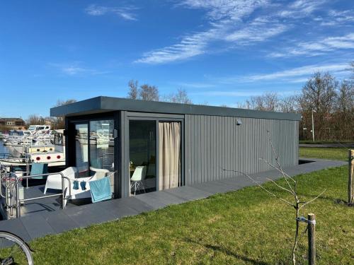 WommelsUniek overnachten in een Tiny House op de Appelhof的一个小房子,带甲板和小船