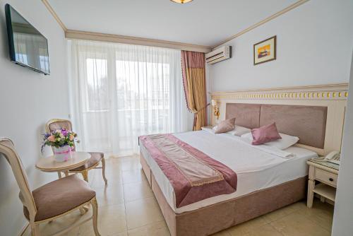 马马亚苏利纳国际酒店的酒店的客房 - 带一张床、椅子和窗户