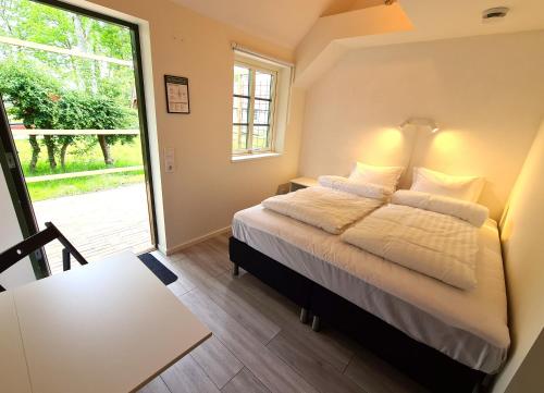 兰斯克鲁纳GEG Hotel的一间卧室配有一张床、一张桌子和一个窗户。