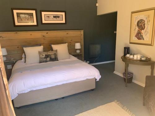 BalgowanNotting Hill Lodge的一间卧室配有一张大床和木制床头板