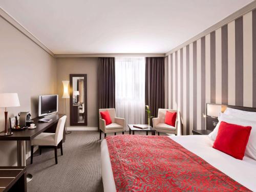 布拉尼亚克铂尔曼图卢兹机场度假酒店的酒店客房,配有一张床、一张桌子和椅子