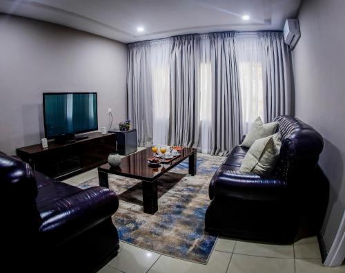 恩多拉MUKUBA HOTEL的客厅配有真皮沙发和茶几