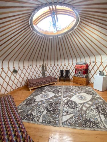VorontsovskoyeRAHMAT yurts的蒙古包内一间铺有大瓷砖地板的客房