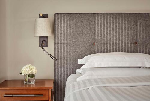 伦敦凯悦伦敦丘吉尔酒店的一间卧室配有一张床和一张带台灯的桌子