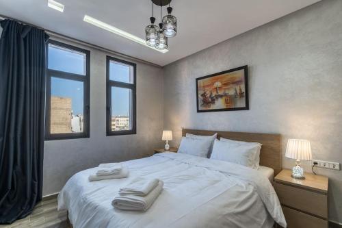 卡萨布兰卡Chic Apartment Cosy Stay的卧室配有一张白色大床和两条毛巾