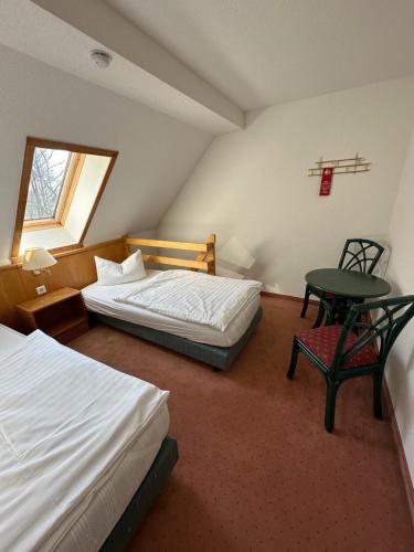 布尔格Hotel am Spreebogen的一间卧室设有两张床、一张桌子和一个窗口