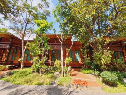Ban Chong PhliAreeya phubeach resort wooden house的前面有树木的木屋