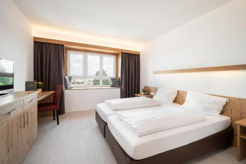霍尔奇臣斯努兹酒店的一间卧室配有一张床、一张书桌和一台电视