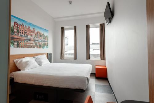 阿姆斯特丹阿姆斯特丹竞技场大道便捷酒店的一间卧室配有一张床,墙上配有电视