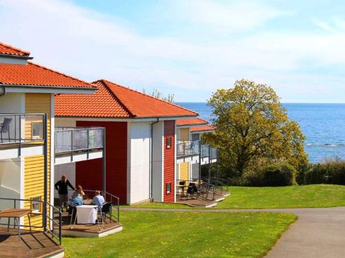 阿灵厄6 person holiday home in Allinge的一组以海洋为背景的房屋