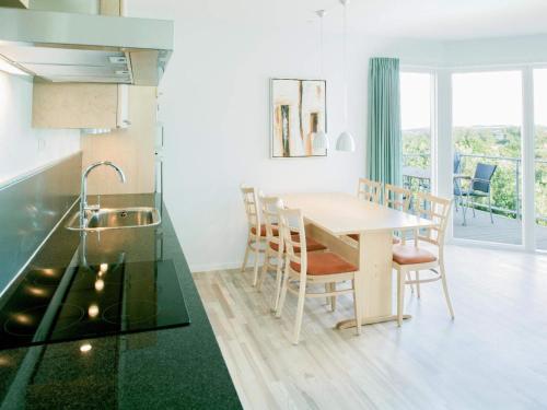 阿灵厄6 person holiday home in Allinge的厨房以及带桌椅的用餐室。