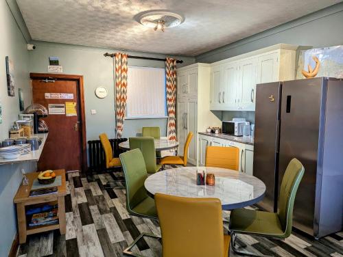 班多伦Fairy Bridge Lodge的厨房配有桌椅和冰箱。